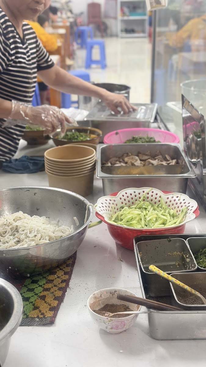Quầy trộn phở với bánh phở, rau thơm và các loại topping